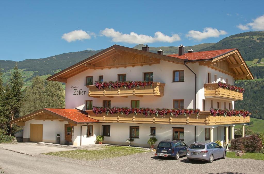 a large white building with flowers on the balcony at Landhaus Zeller in Fügenberg