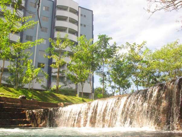 a waterfall in front of a building next to a building at Apartamento no Aguas da Serra TOP in Rio Quente