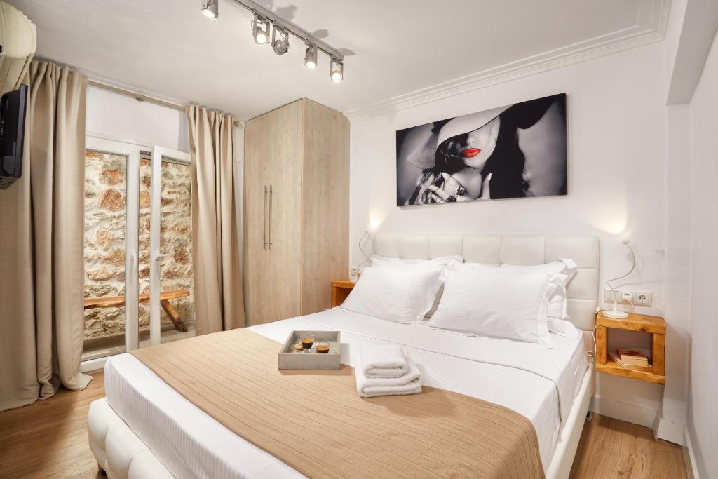 sypialnia z dużym białym łóżkiem z białymi poduszkami w obiekcie warm stone house w Atenach