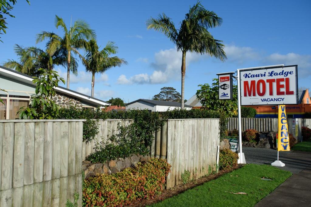 una señal de motel frente a una valla en Kauri Lodge Motel, en Kaitaia