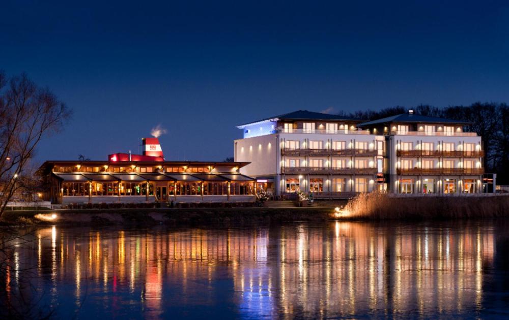 a large building next to the water at night at Riverside Hotel in Nordhorn