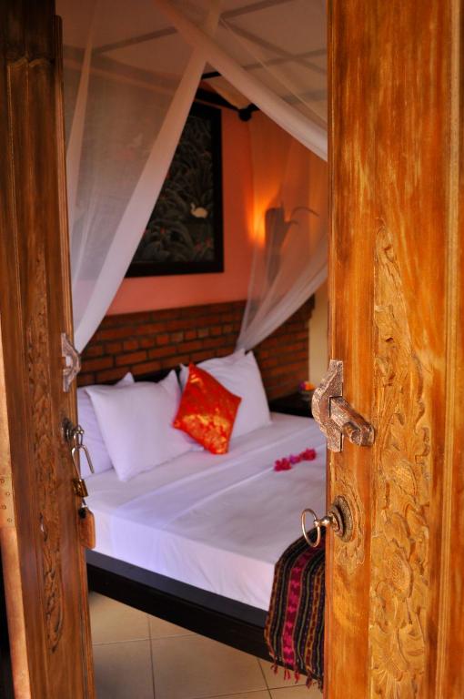 Postel nebo postele na pokoji v ubytování Tirta Sari Bungalow