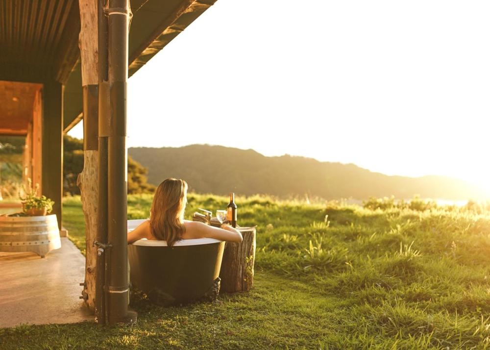 Una donna seduta in una vasca da bagno in un campo di Golden Bay Hideaway a Takaka