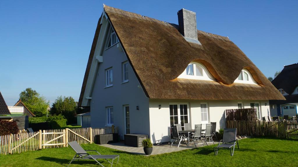 a large white house with a thatched roof at Reethaus Casa Baltica in Börgerende-Rethwisch