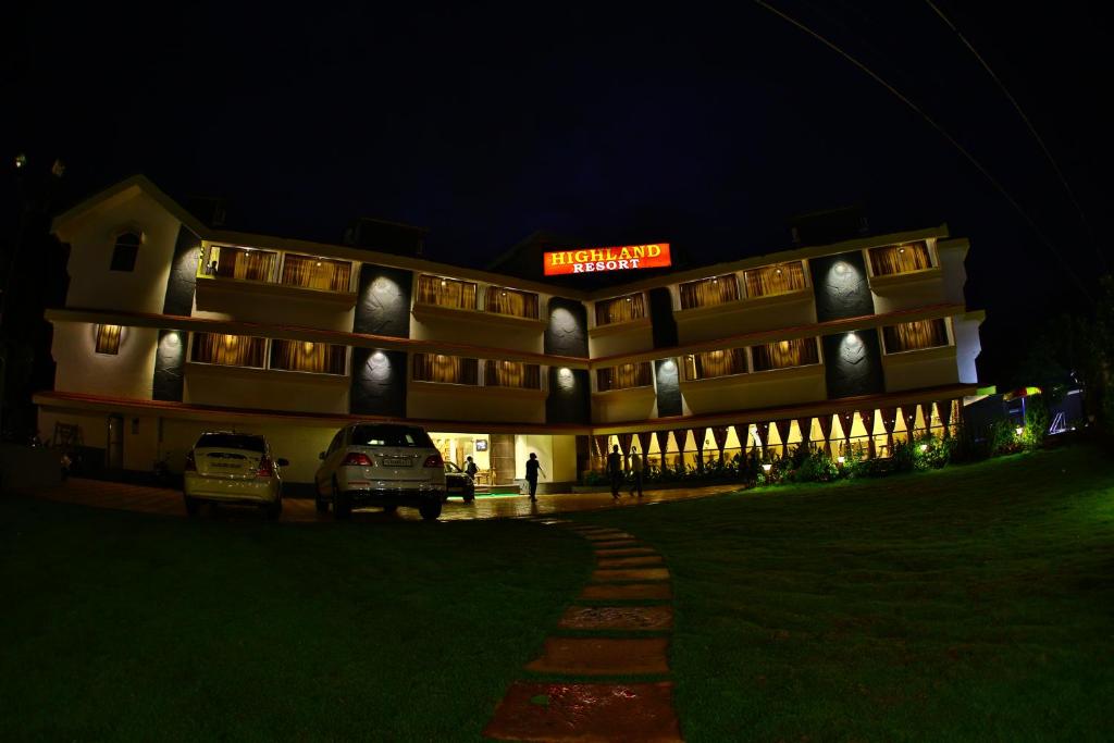 a building with cars parked in front of it at night at Highland Resort in Lonavala