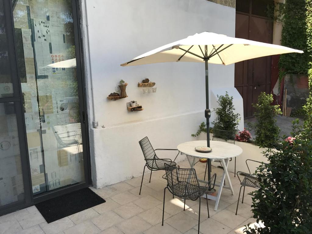 a table and chairs with an umbrella on a patio at Beeloft in Catania