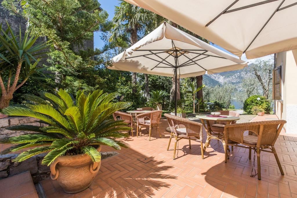 un patio con tavoli, sedie e ombrellone di B&B Casa Benamati by Kelly a Malcesine
