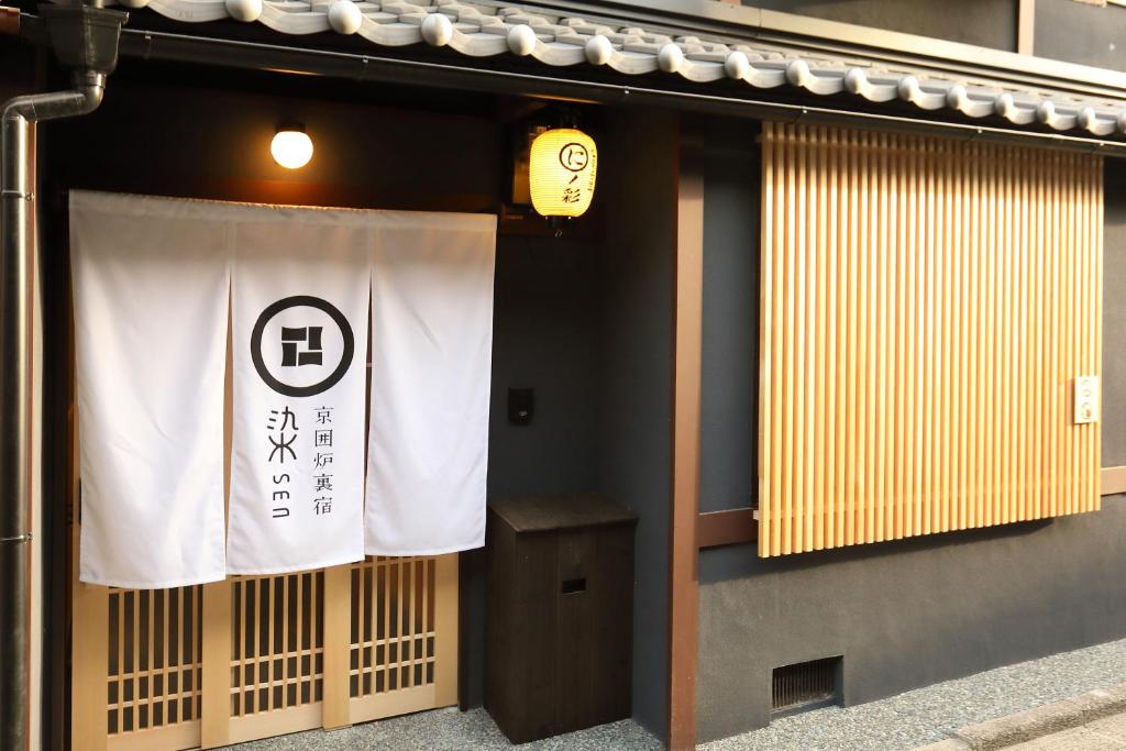 una señal en el lateral de un edificio con una pancarta en 染 SEN 七条壬生 Shichijo-Mibu, en Kioto