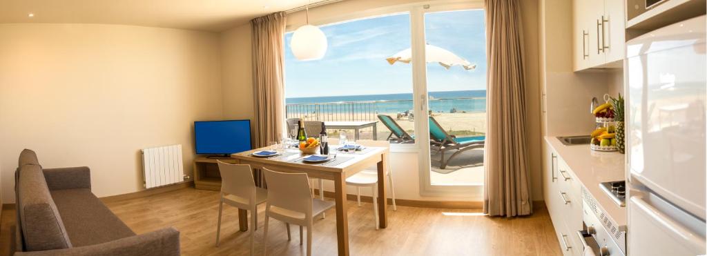 a kitchen and dining room with a view of the beach at Apartamentos Voramar in Castelldefels