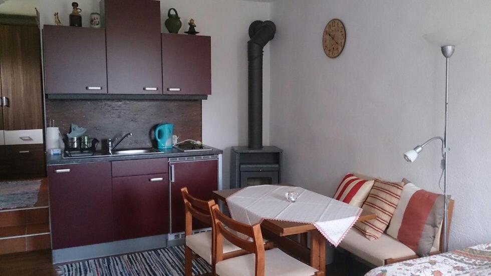 a living room with a table and a kitchen with a stove at Altes Presshaus in Eberau