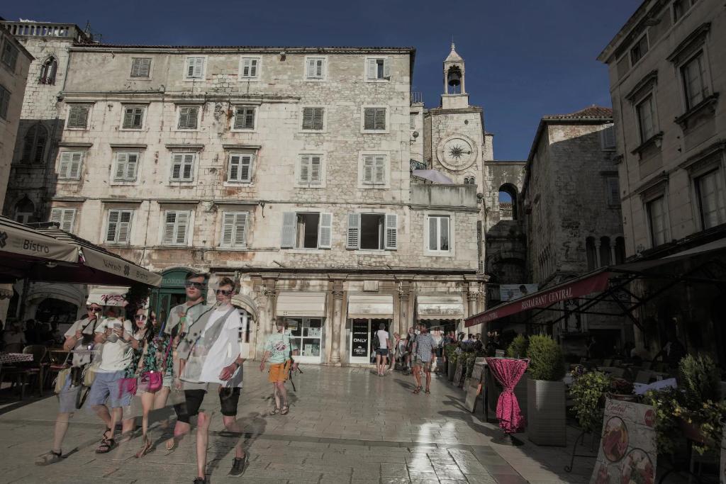 a group of people walking down a city street at Apartments Fortezza in Split