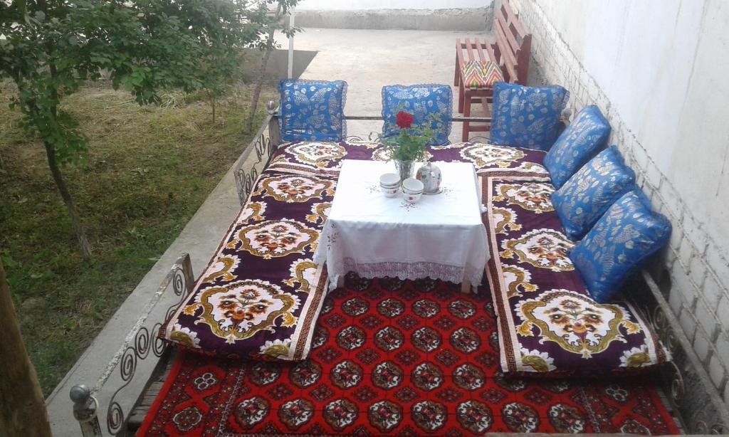 una mesa con mantel blanco y sillas azules en Western house, en Qorowul