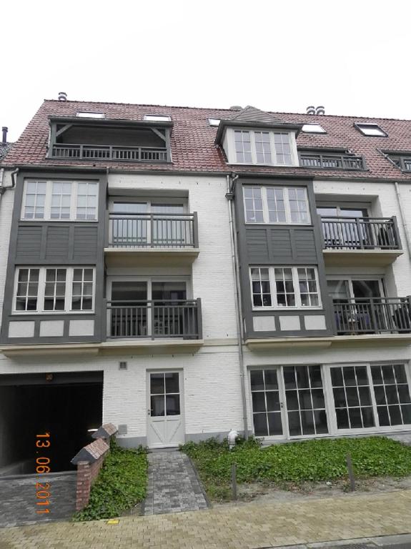 a large white building with windows and a door at Appartement 3 Chambres A Koksijde in Koksijde