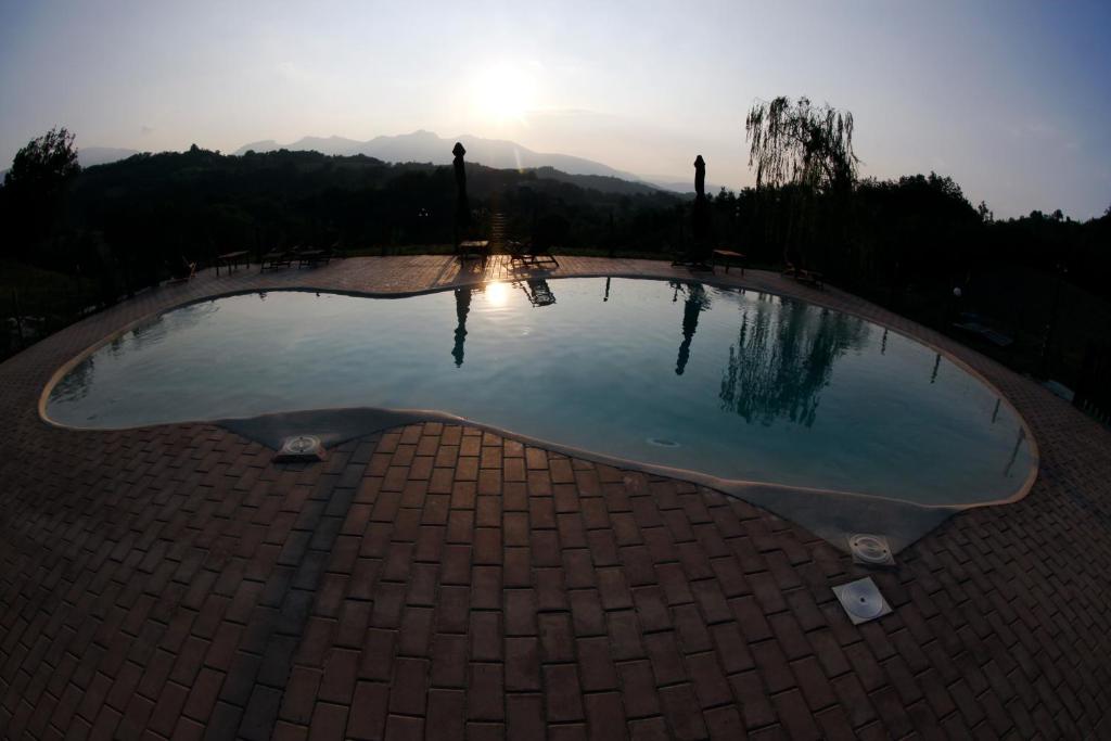a pool of water with the sunset in the background at Terra di Magie in Sarnano