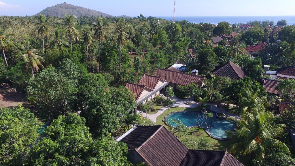 佩母得蘭的住宿－Doubleyou Homestay Pemuteran，享有带游泳池和树木的度假村的空中景致