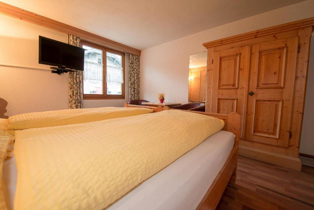 a bedroom with a bed with a yellow bedspread at Crusch Alba in Scuol