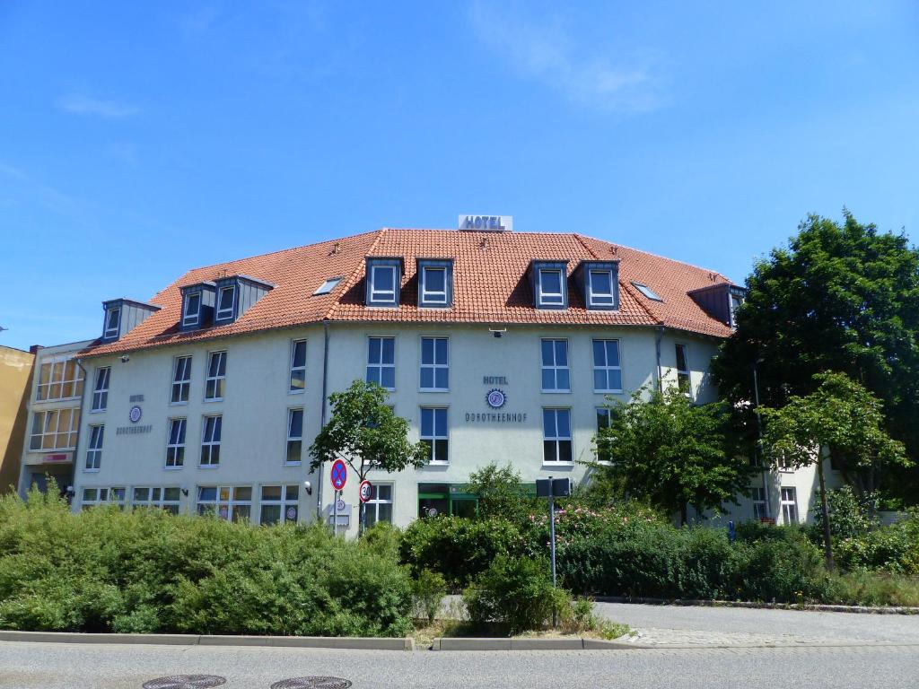 un grand bâtiment blanc avec un toit rouge dans l'établissement Hotel Dorotheenhof, à Cottbus