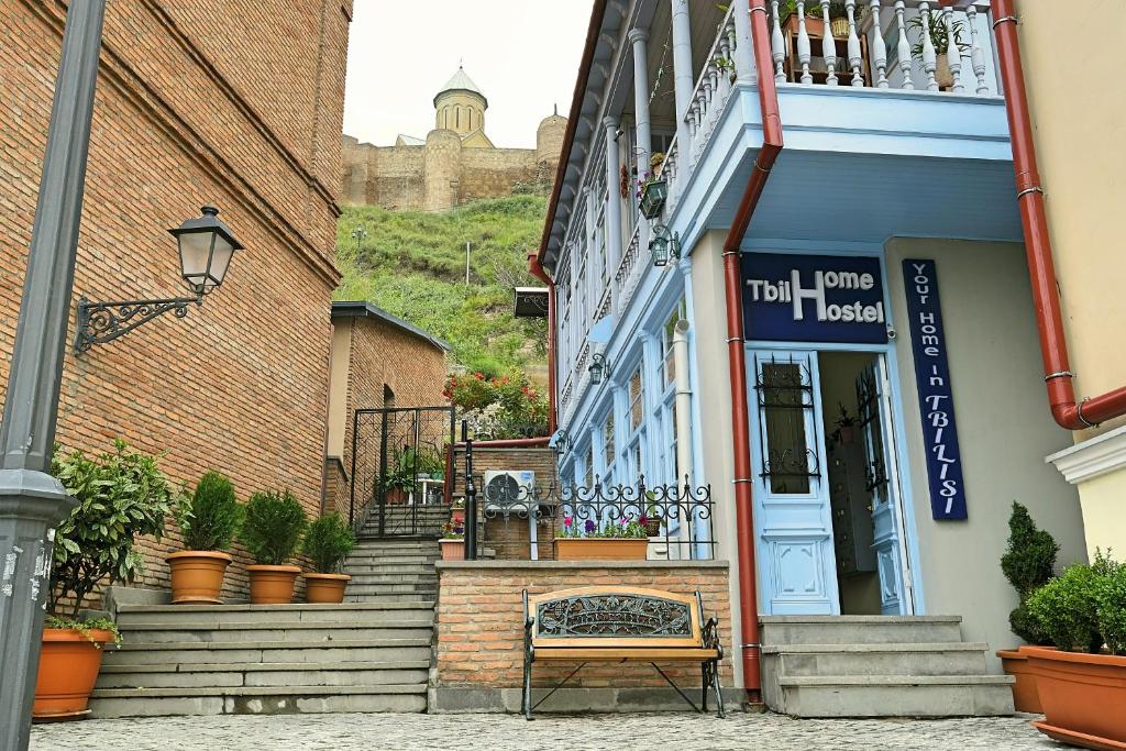 um edifício com um banco em frente a um edifício em Tbil Home Hostel em Tbilisi