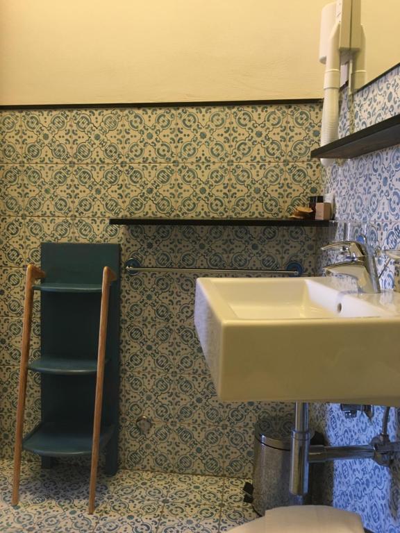 łazienka z umywalką i zielonym krzesłem w obiekcie Al Castello Affittacamere w mieście Pietra Ligure