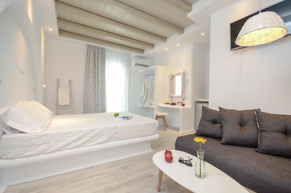 a living room with a bed and a couch at Naxian Spirit Suites & Apartments in Agia Anna Naxos