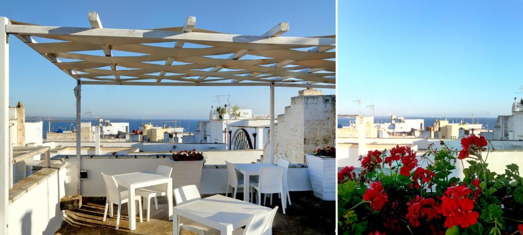 une table et des chaises blanches sur un toit avec des fleurs rouges dans l'établissement B&B Dimora Muzio and Restaurant, à Gallipoli