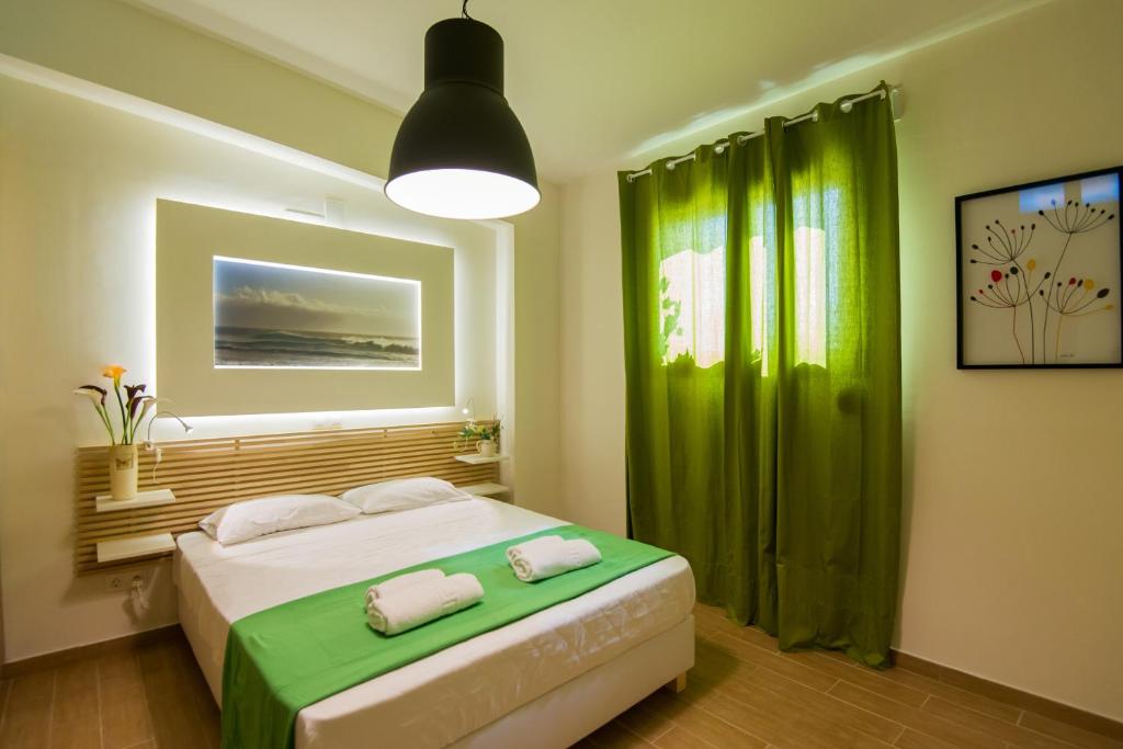 パノルモス・レティムノにあるCastello Di Portoのベッドルーム1室(緑のカーテン付きのベッド1台付)