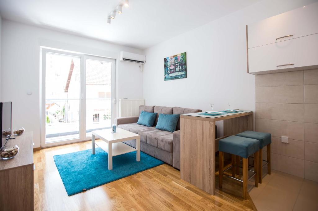 ein Wohnzimmer mit einem Sofa und einem Tisch in der Unterkunft Jelena Apartment in Doboj