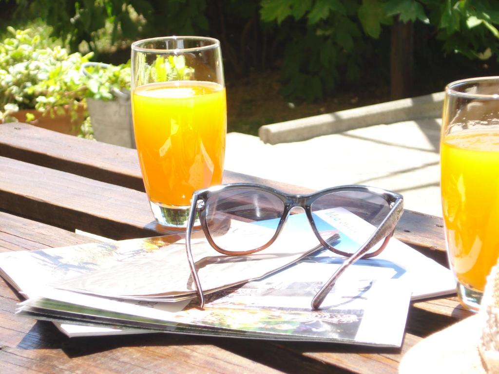 a pair of glasses sitting on a table with two drinks at Studio Apartment MD in Roč
