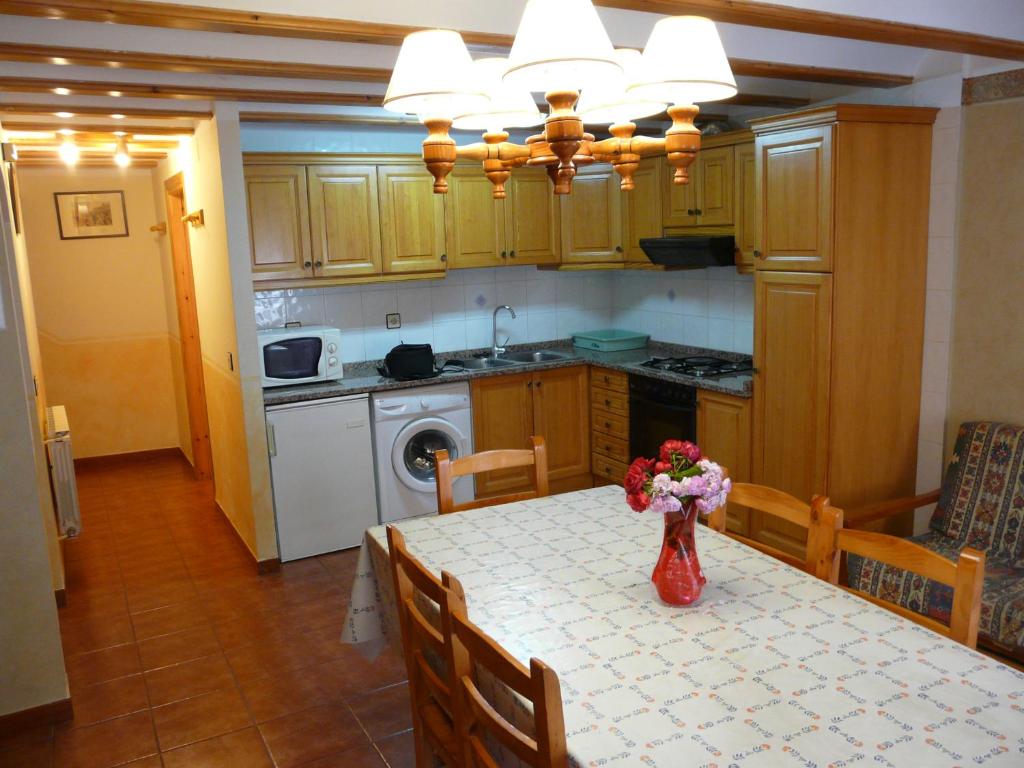 Una cocina con una mesa con un jarrón de flores encima. en Casa Marcos, en Castellote