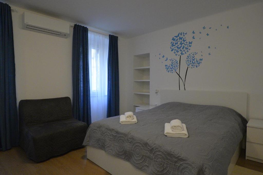 um quarto com uma cama e uma cadeira em Apartments and Rooms Oliva em Cres