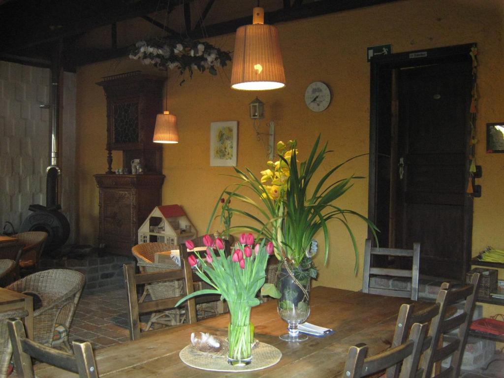 una mesa de comedor con un jarrón de flores. en Die bunte Kuh in Federow, en Kargow