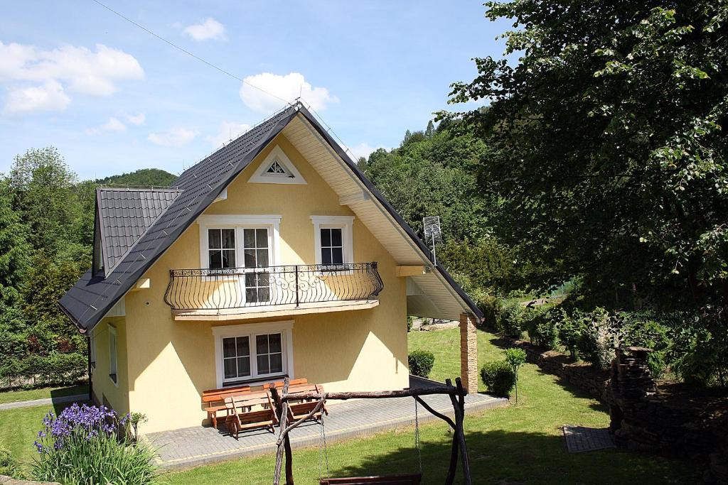 Casa amarilla con balcón y porche en Dom Aga Bieszczady 10 osobowy en Bukowiec