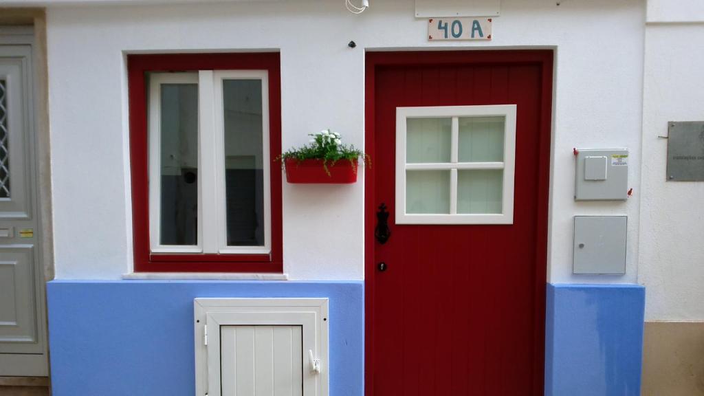 a house with a red door and a window at Estúdio 40A in Nazaré