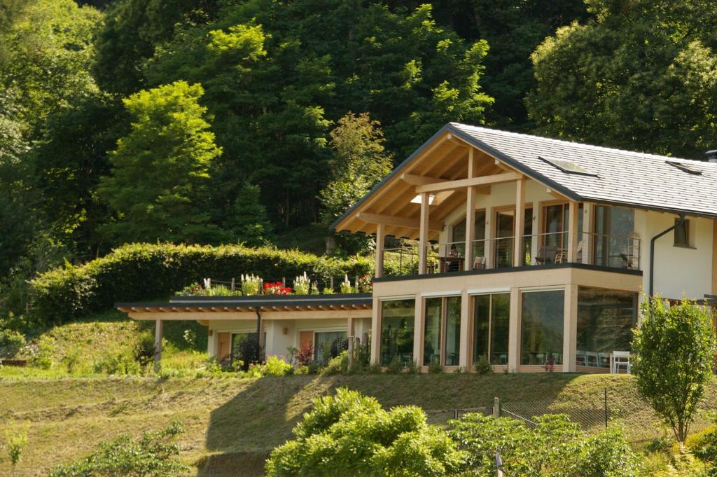 una casa su una collina con alberi sullo sfondo di Agriturismo Verdecrudo a Caldonazzo