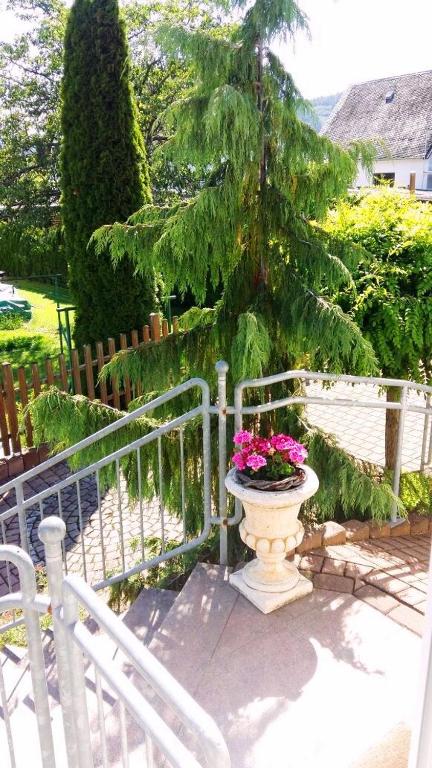 a vase with flowers in it next to a fence at Ferienwohnung Eigner in Traben-Trarbach