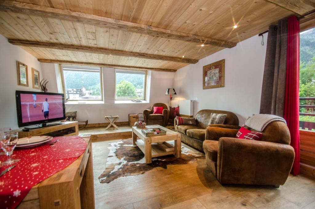 sala de estar con sofá y TV en Appartement Acacia, en Chamonix-Mont-Blanc