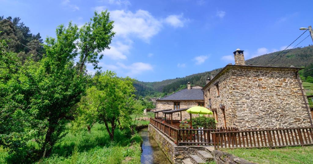 a stone house with a deck and a building at Casas da Lexa in Taramundi