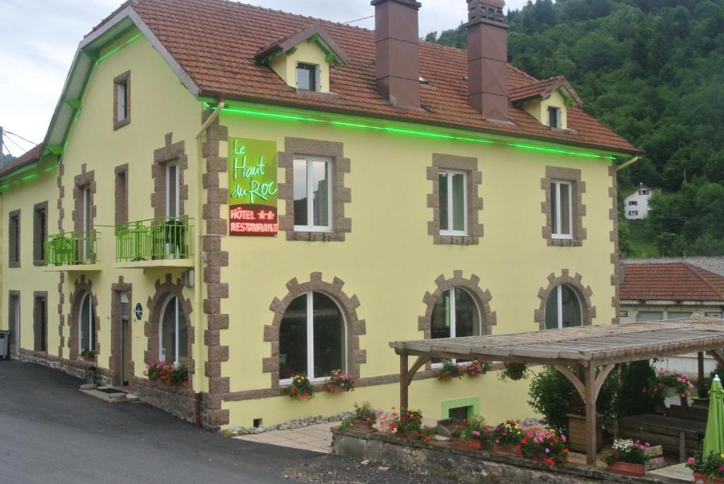 un bâtiment jaune avec un panneau sur lequel figure un panneau dans l'établissement Hotel Restaurant Du Haut Du Roc, à Basse-sur-le-Rupt