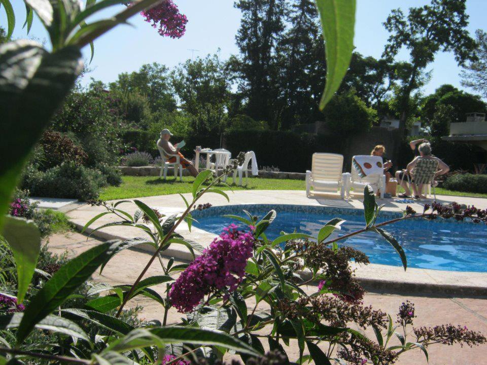 a swimming pool with people sitting in chairs by it at Villa Camila in Villa Giardino