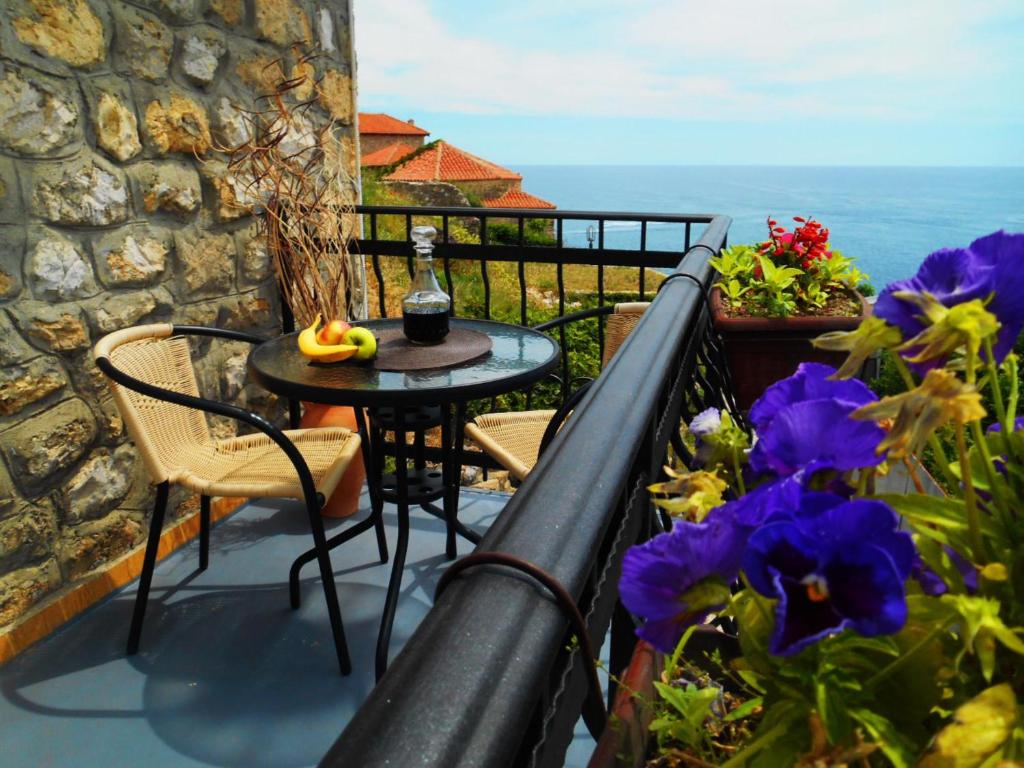 a balcony with a table and chairs and flowers at Apartments Zuto in Ulcinj