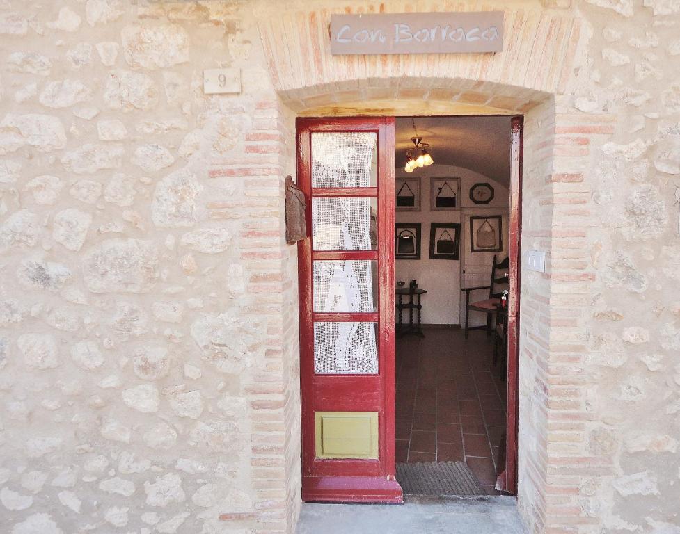 una porta rossa che conduce a una camera con tavolo di Can Barraca ad Avinyonet de Puigventós