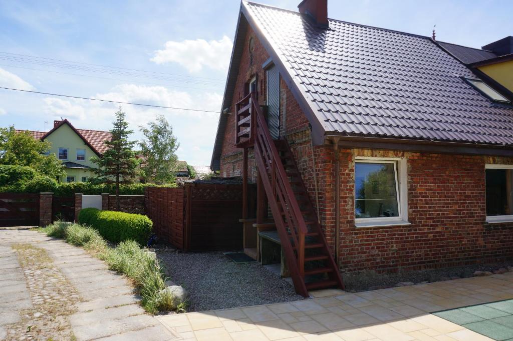 une maison avec une échelle sur son côté dans l'établissement Domek przy plaży, à Rewa