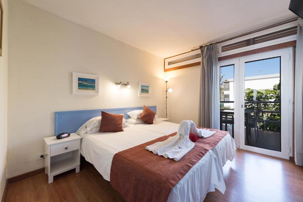 a bedroom with a large bed and a balcony at Apartamentos El Paseo in Playa del Ingles