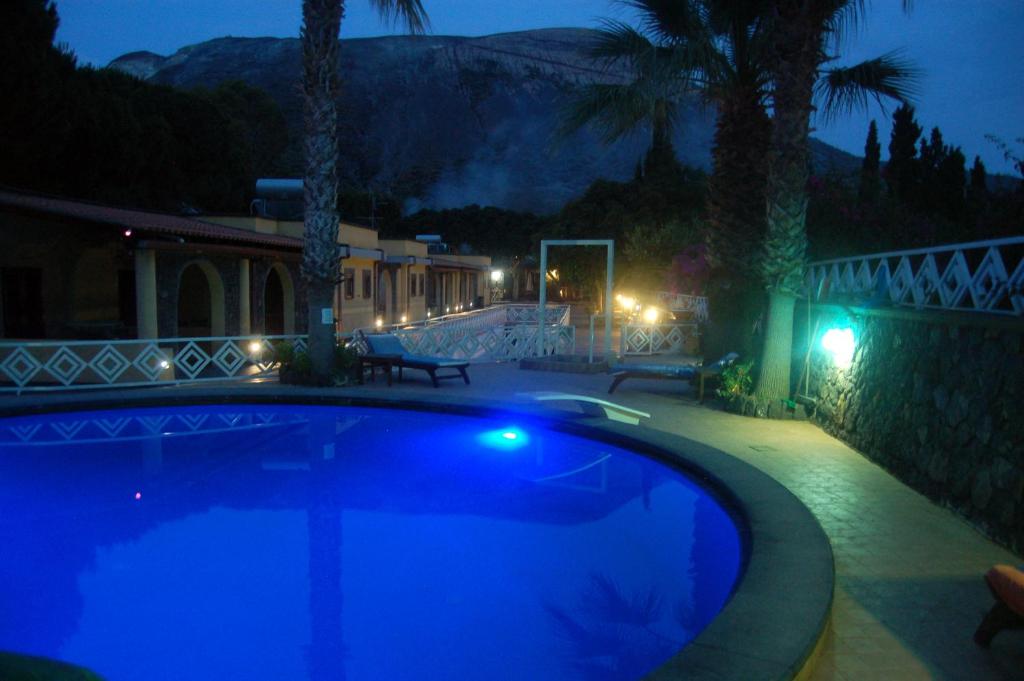 una piscina notturna con una casa di Hotel Al Togo Fitness & Relax a Vulcano