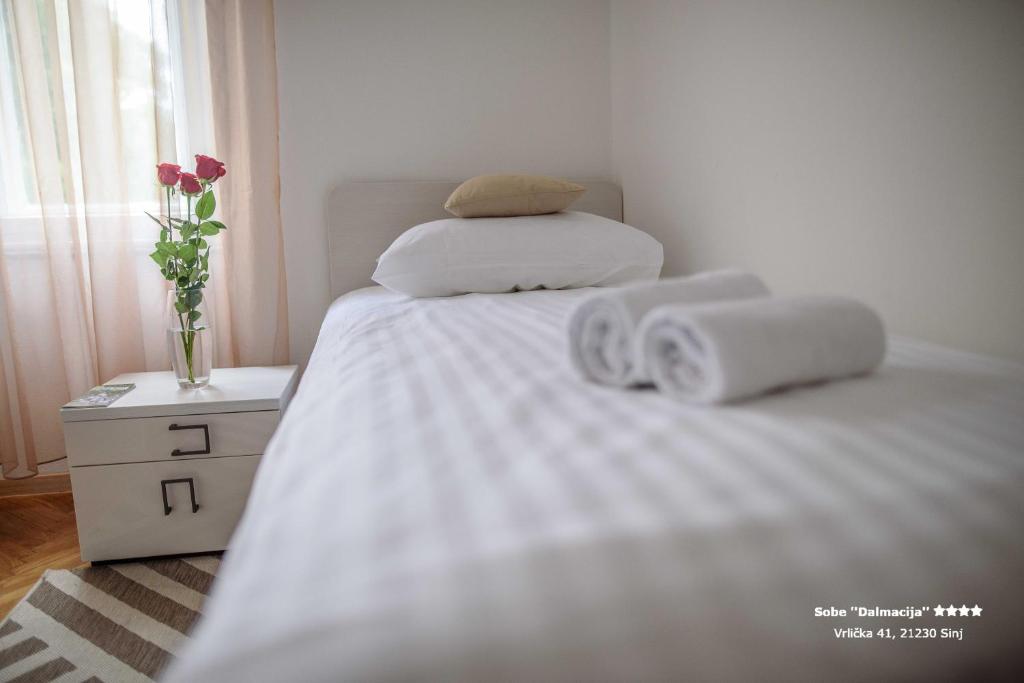 a bedroom with a bed with two towels on it at Apartment/Room ''Dalmacija'' SINJ in Sinj