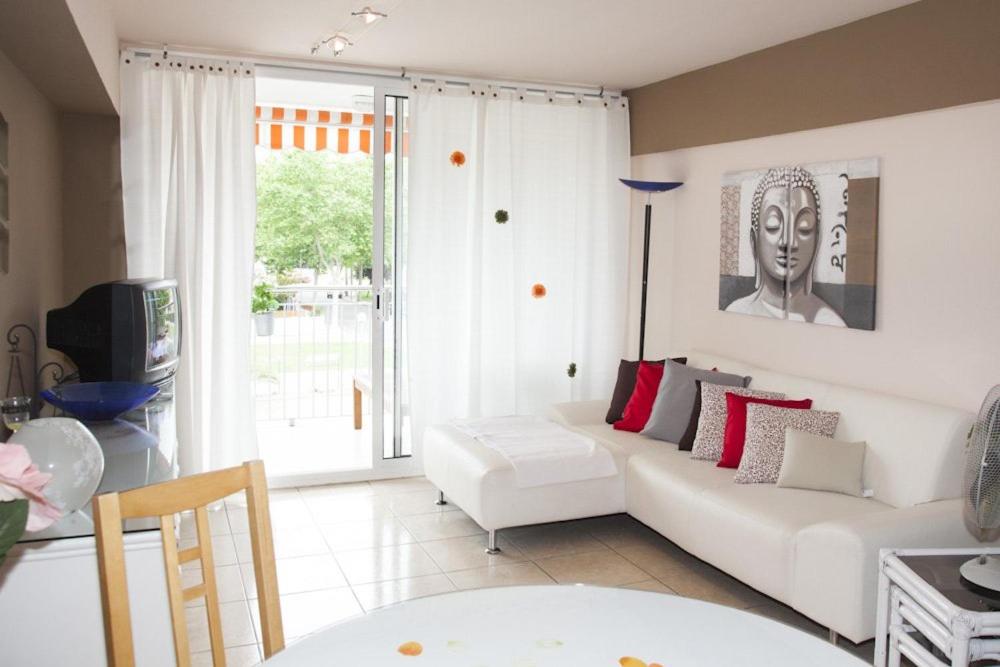 a living room with a white couch and a window at Arogran II in Platja d'Aro