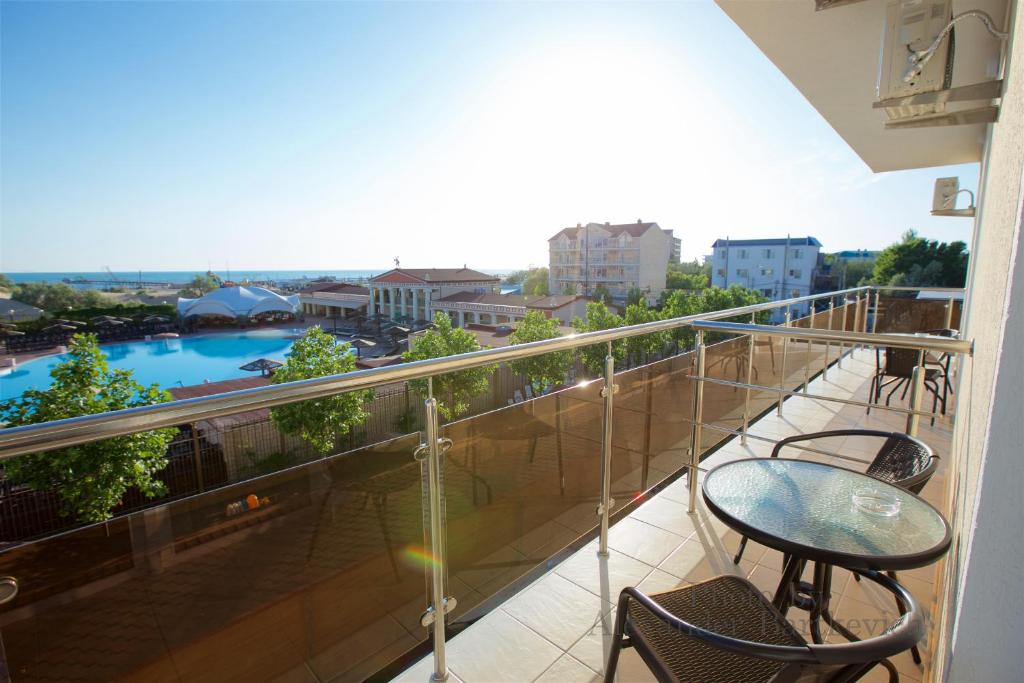 a balcony with a table and chairs and a view at Hotel Greek in Vityazevo