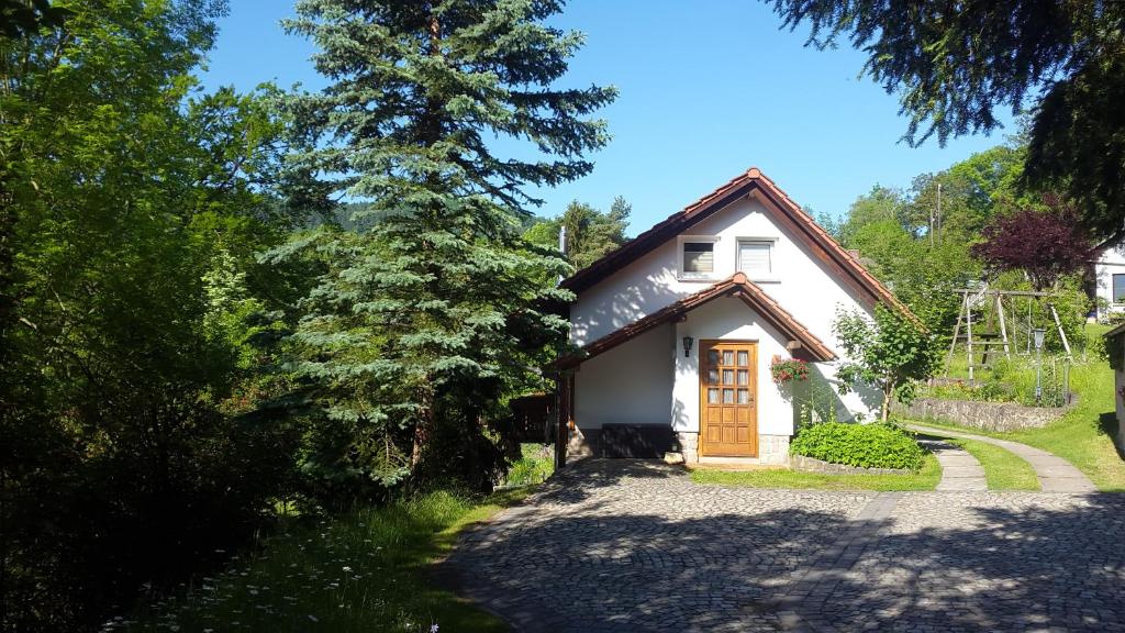 een klein wit huis met een oprit bij Ferienhaus "Am Schleifenbach" in Saalfeld