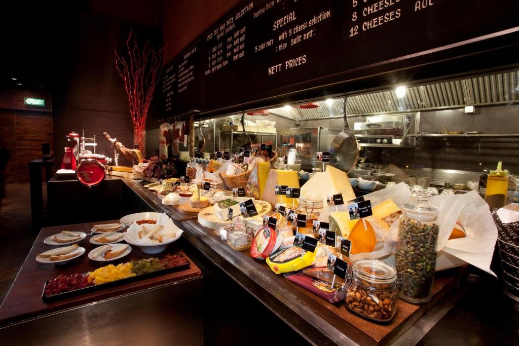 A buffet counter displays breakfast foods and drinks in an open restaurant kitchen.