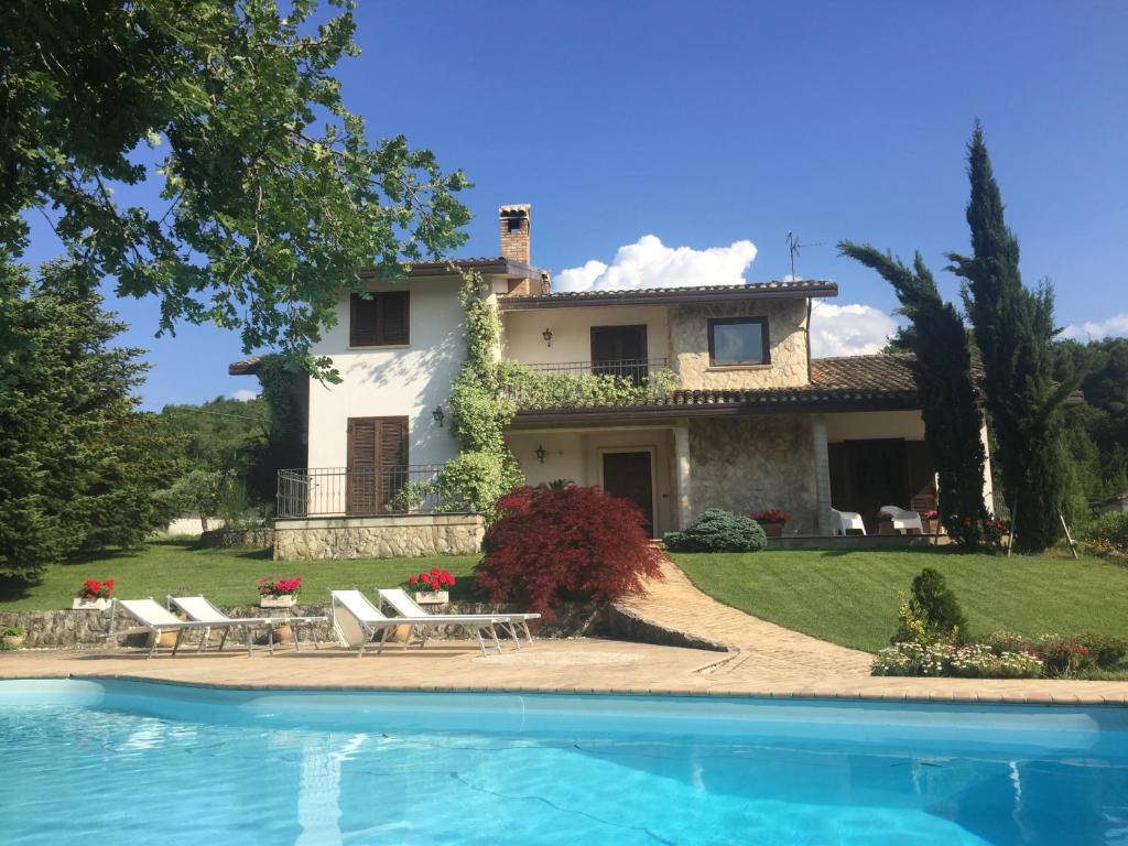 une villa avec une piscine en face d'une maison dans l'établissement Villa Nicolai tra Mare e Montagna, à Lettomanoppello